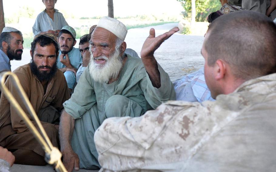 Marine 1st Lt. Christopher Young, right, listens as an old man describes the problems of his community in Marjah on June 18. Young was trying to convince the elders to give their young men arms to help fight off insurgents.