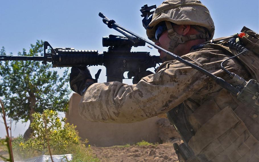 Cpl. Chad Wilson, a Marine squad leader, lets off a burst of rifle fire during a fight with insurgents in Marjah on June 20. Wilson said the insurgents were trying to lure the Marines to two buildings across an open field that were known to have IEDs set in front of them.