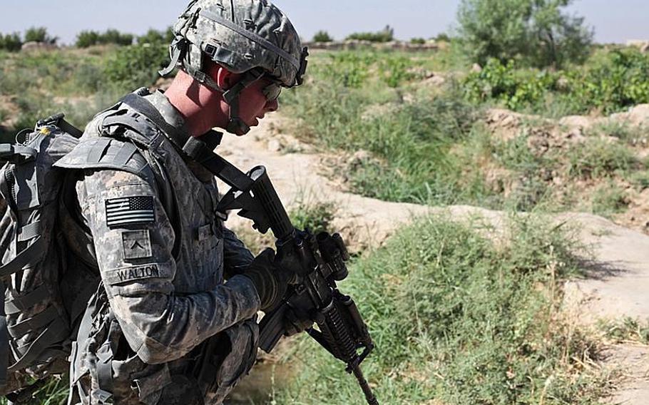 Pvt. Sean Walton, of Troop B, 1st Squadron, 71st Cavalry Regiment, keeps an eye for mines and tripwires during a patrol in Dand district, Kandahar province, Afghanistan. June 19, 2010.