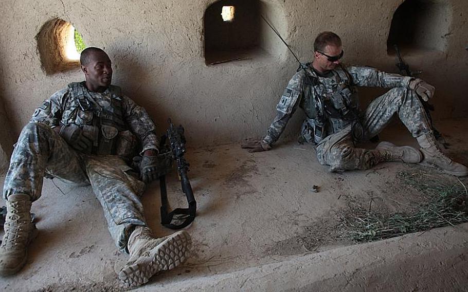 Spc. Colby Anderson, left and Staff Sgt. Richard Balch, right, of Troop B, 1st Squadron, 71st Cavalry Regiment, take a break during a patrol in Dand district, Kandahar province, Afghanistan. June 19, 2010.