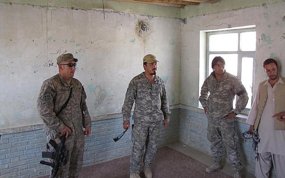 Soldiers and Afghans gather in a 12-by-14-foot classroom in the village of Marjab that an elder said accommodates 40 young boys.