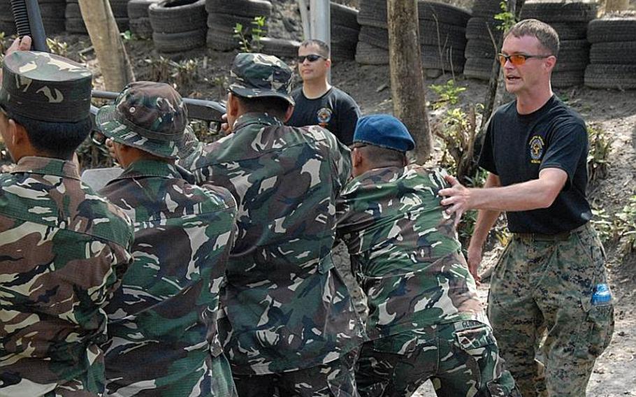 Okinawa-based U.S. Marines with the 3rd Marine Expeditionary Force's Special Operations Training Group instruct Filipino troops in the use of nonlethal weapons during the 2009 Balikatan training exercise Friday on what was once the U.S. Air Force's Clark Air Base.