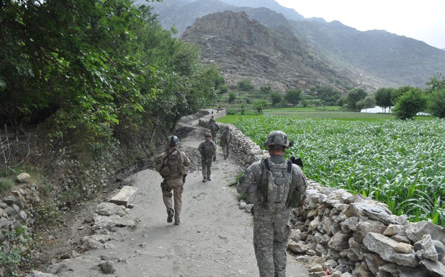 U.S. soldiers patrol the villages outside their base, Combat Outpost Michigan, on July 20, walking past tall-growing corn that soldiers have begun paying villagers not to grow. Insurgents hide amid the tall crops to shoot at Afghan and coalition forces.