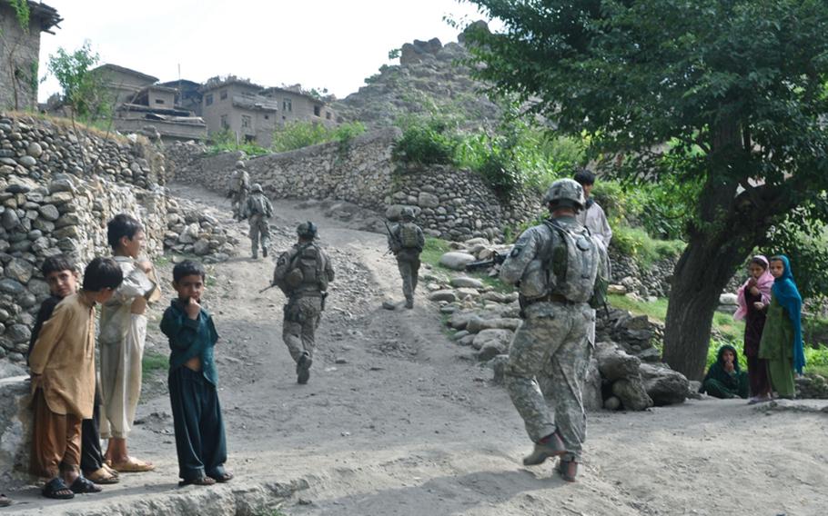 Soldiers walk through a village not far from their base, Combat Outpost Michigan, during a patrol on July 20.