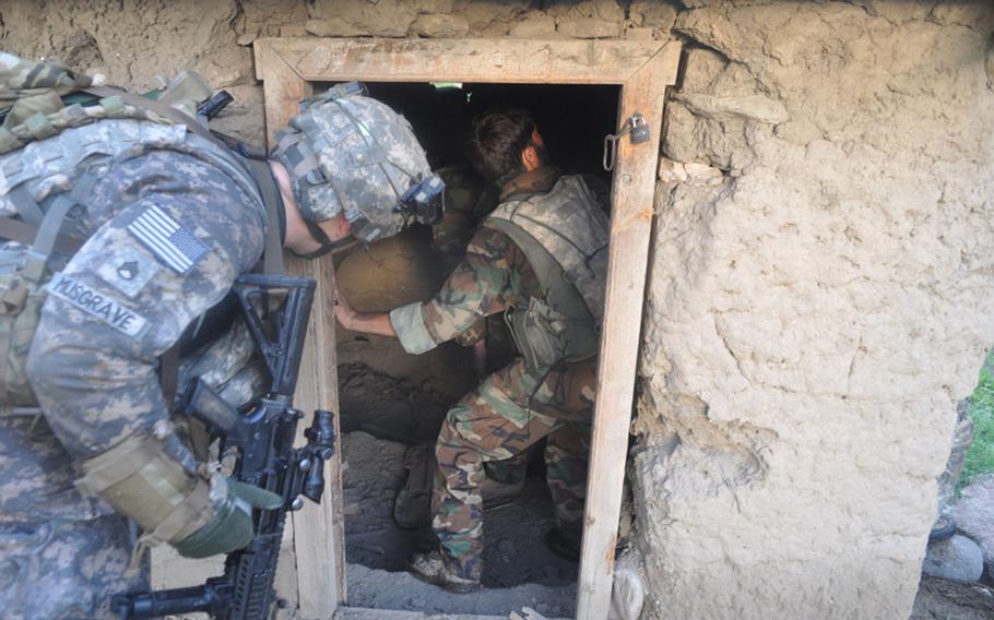 U.S. and Afghan soldiers search a field shack in Chinar village on July 21, looking for weapons used by insurgents to fire at their base from the village at the mouth of the Korengal Valley.