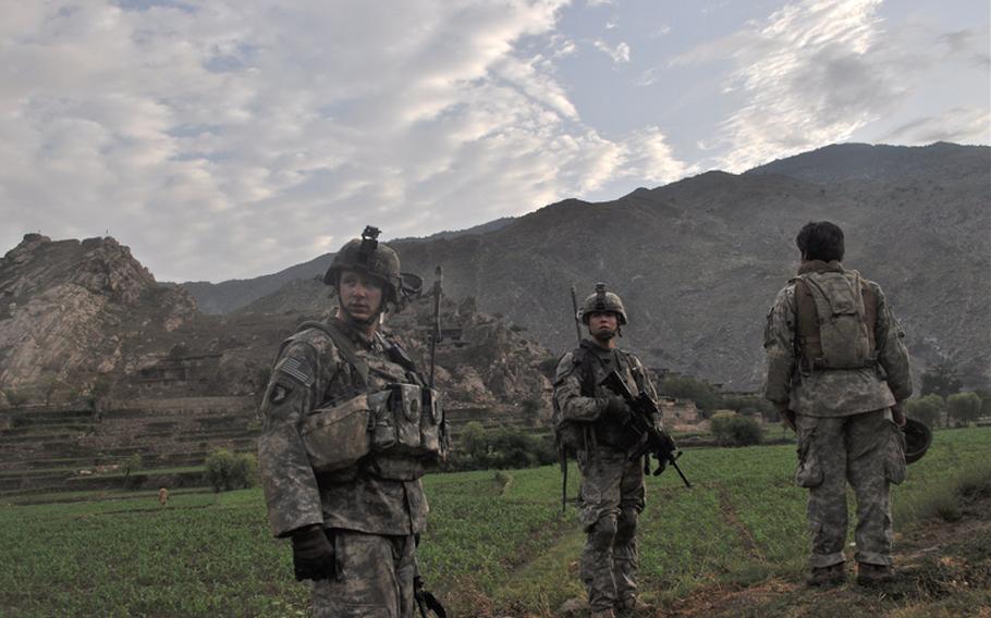 U.S. soldiers search fields in the hostile village of Chinar at the mouth of the Korengal Valley on July 21 for insurgent weapons.