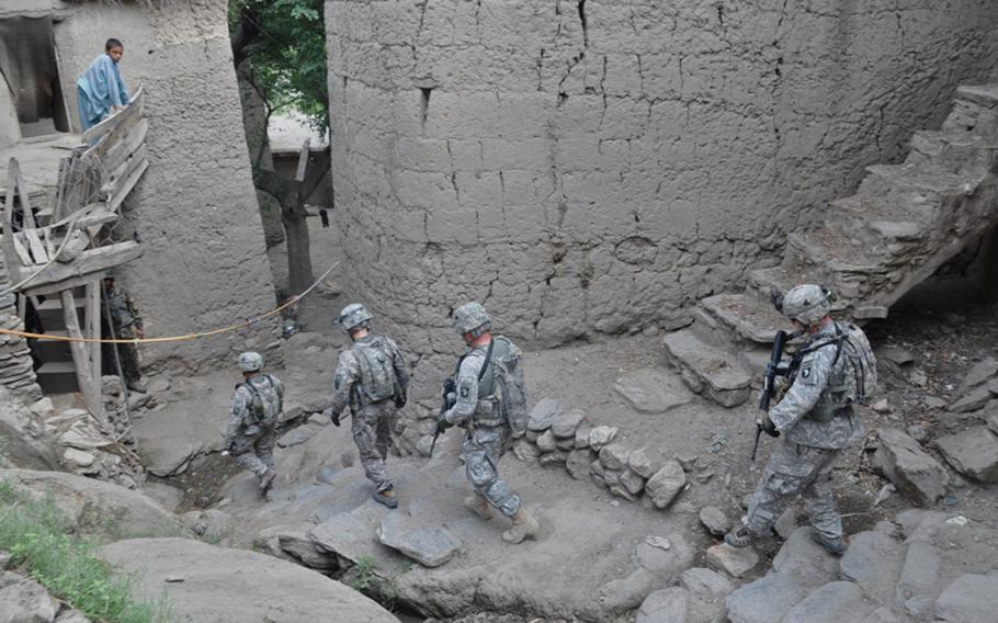 Soldiers walk through a village not far from their base, Combat Outpost Michigan, during a patrol on July 20.