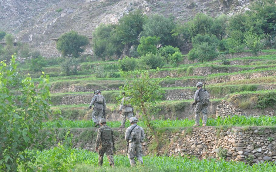 U.S. soldiers search the terraced fields of the hostile Chinar village on July 21, looking for weapons insurgents use to attack their base, Combat Outpost Michigan.