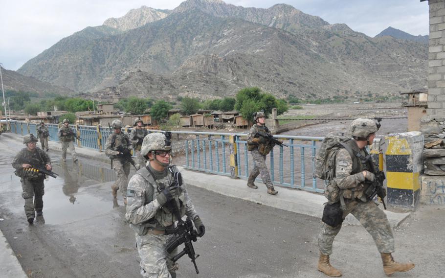 U.S. soldiers cross a bridge over the Pech River on July 21 as they return to their base, Combat Outpost Michigan, following a patrol.