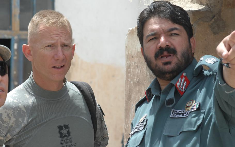 Lt. Col. Douglas Sims, left, commander of the 1st Squadron, 2nd Stryker Cavalry Regiment, meets with Gen. Juma Gul, commander of Afghan National Police in Uruzgan province, to find out why many of his men don't have AK-47 rifles.