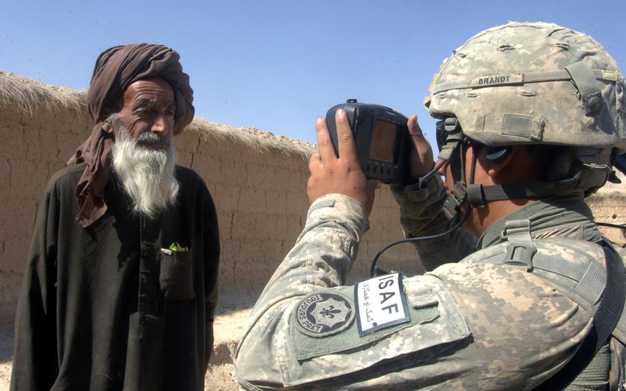 Spc. Clifford Brandt, 24, of Killeen, Texas, photographs an Afghan farmer in Helal China, an isolated village in Zabul province's Shah Joy district.