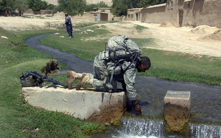 Cpl. Brandon Turner, 23, of Fort Pierce, Fla., cools off in one of the many streams flowing through Helal China, an isolated village in Zabul province's Shah Joy district.