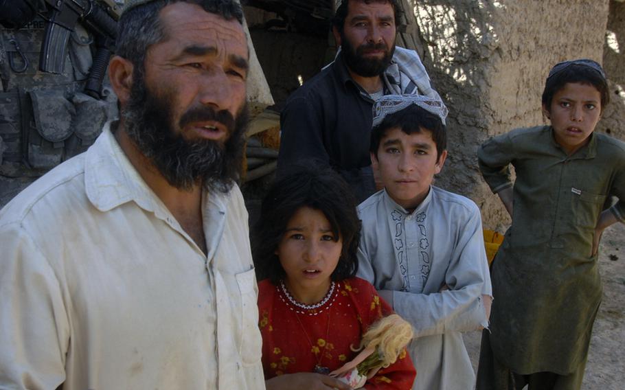 A farmer and his family talk to American soldiers in Helal China, an isolated village in Zabul province's Shah Joy district.