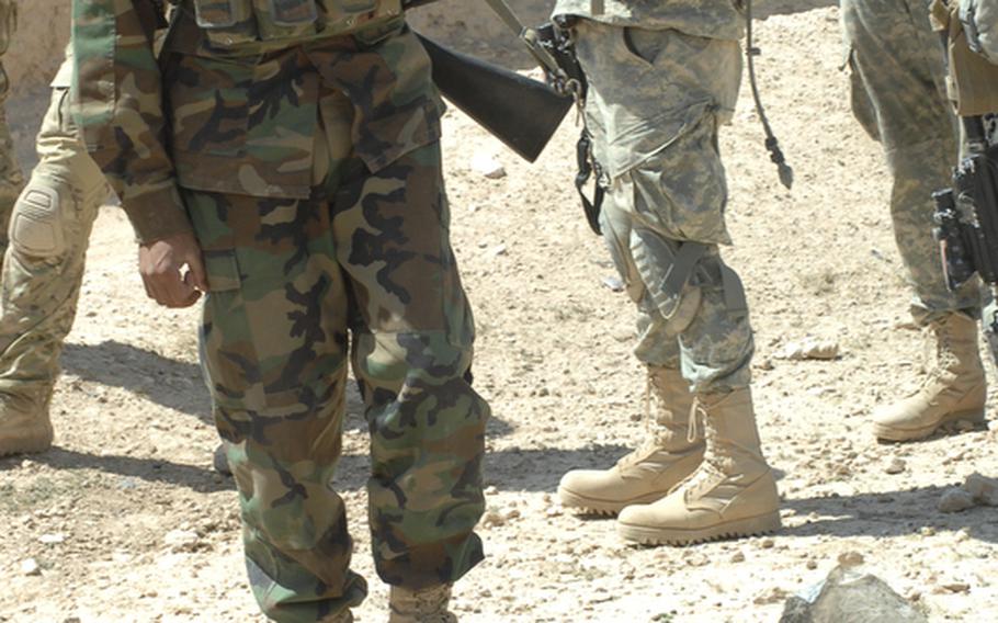 An Afghan soldier examines the remains of a roadside bomb after it was destroyed in Helal China, Zabul province, Afghanistan.