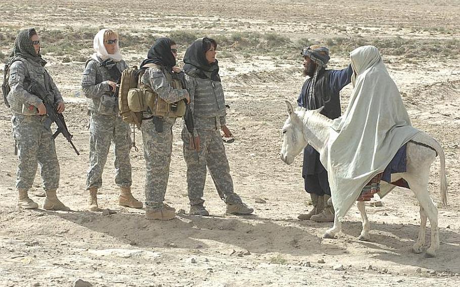 Female Engagement Team members Pfc. Kelly Shutka, 22, of Pine Glen, Pa., Pfc. Rachel Miller, 39, of Northumberland, Pa., Sgt.  Richelle Aus, 25, of Michigan City, Ind., and Laila Khoshnaw prepare to search a woman being led to a medical clinic on a donkey by her husband Zabul province, Afghanistan.