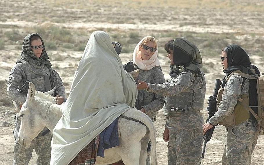 Female Engagement Team members Pfc. Kelly Shutka, 22, of Pine Glen, Pa., Pfc. Rachel Miller, 39, of Northumberland, Pa., Laila Khoshnaw and Sgt. Richelle Aus, 25, of Michigan City, Ind., prepare to search a woman on a donkey in Zabul province, Afghanistan.