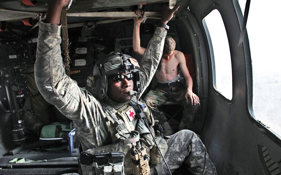 Staff Sgt. Rakheem Francis, 24, of Queens, N.Y., a flight medic with the 101st Combat Aviation Brigade's Task Force Shadow, takes a break Sept. 19 after transporting a severely wounded Afghan soldier at a  NATO military hospital at Kandahar Air Field, Afghanistan. Another wounded Afghan soldier who had suffered a gunshot wound to the side and minor facial wounds sits in the seat behind him.