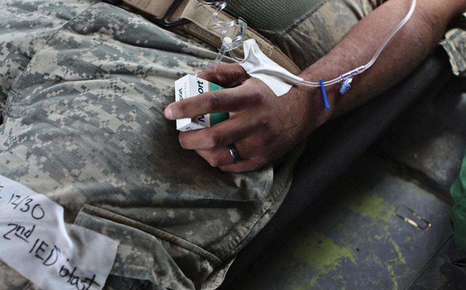 A soldier wounded in a Taliban bomb blast near the city of Kandahar, Afghanistan, clutches a pack of cigarettes in his hand while being transported to a NATO military hospital by a helicopter ambulance with the 101st Combat Aviation Brigade&#39;s Task Force Shadow. Sept. 21, 2010.