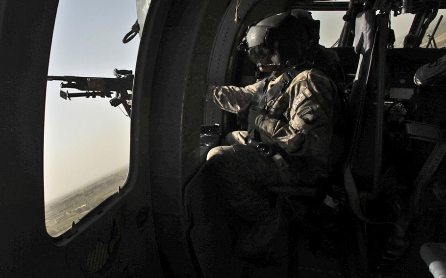 Spc. Eduardo Cantoran, 20, of North Andover, Mass., mans a M240 machine gun on a UH-60 Black Hawk helicopter, providing an armed escort for a helicopter ambulance with the 101st Combat Aviation Brigade&#39;s Task Force Shadow. Sept. 24, 2010.