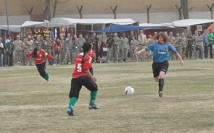 A member of the ISAF women's soccer team, right, and a player on the Afghan national women's soccer team both close in on the ball during a friendly match at ISAF Headquarters on Friday in Kabul.