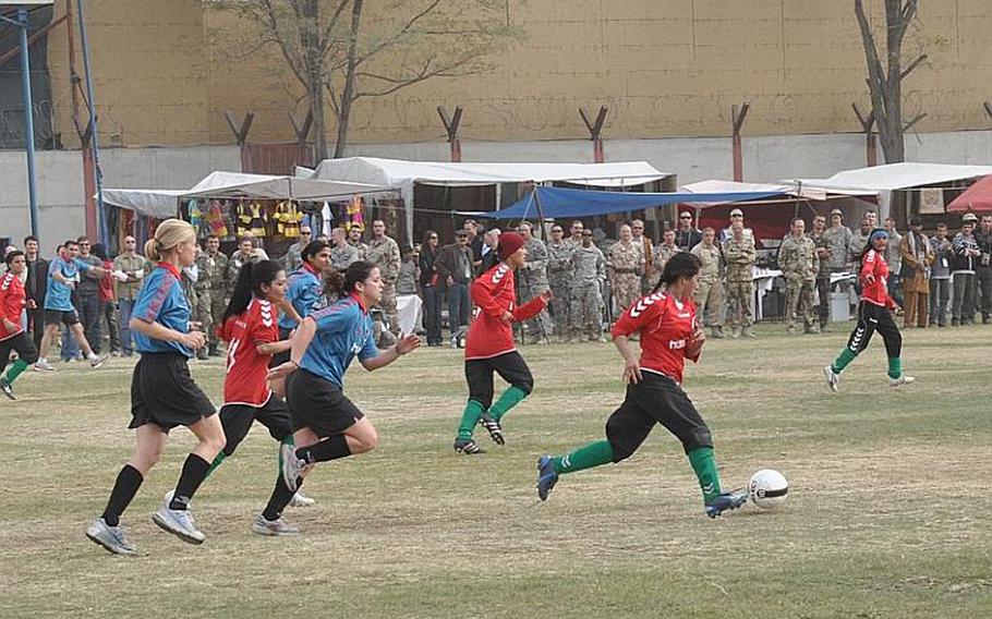The Afghan national soccer team gets control of the ball and heads downfield in a friendly match against the ISAF women's team at ISAF Headquarters on Friday in Kabul.