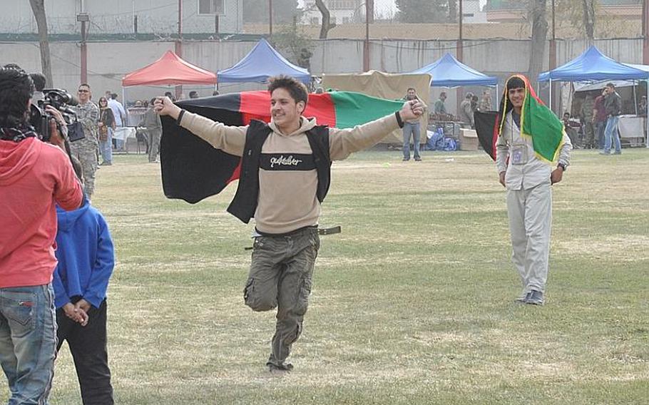 An Afghan supporter runs around the soccer field after the Afghan national women's soccer team scored a goal against the ISAF women's team during a friendly match Friday at ISAF Headquarters in Kabul.