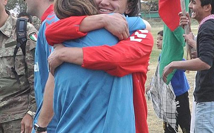 A member of the ISAF women's soccer team, left, and a player from the  Afghan women's national soccer team embrace after a match at ISAF Headquarters in Kabul on Friday.