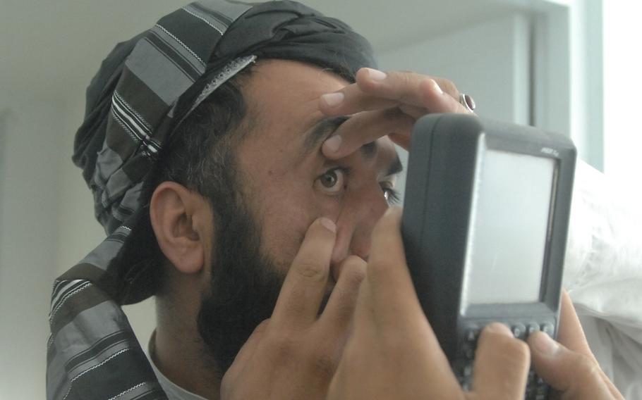 A man opens his eye for a biometric scan at the Afghan border town of Wesh on Sept. 22.
