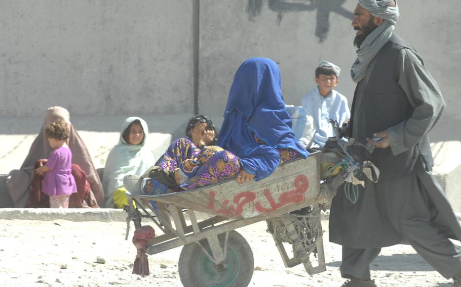 A man pushes a woman in a wheelbarrow across the border from Pakistan into Spin Boldak district, Afghanistan on Sept. 22.