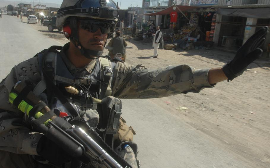 Afghan Border Police officer Sgt. David Haytullah, 20, directs traffic near the border with Pakistan in Spin Boldak district, Afghanistan on Sept. 22.