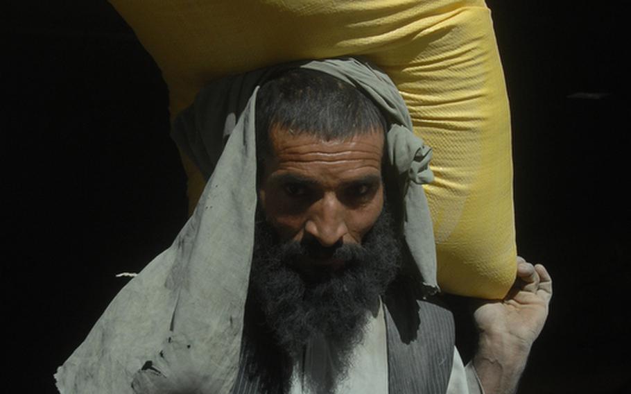 A man carries a bag of grain in Spin Boldak district, Afghanistan on Sept. 22. U.S. soldiers there suspect large amounts of bomb making chemicals are being smuggled into the country amongst other imports.