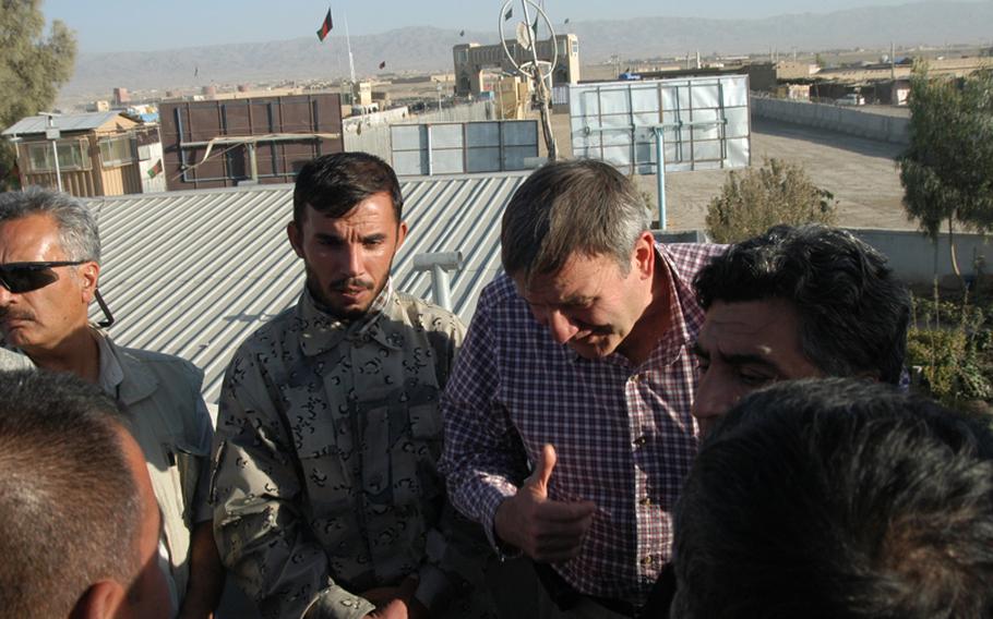 With the Afghanistan-Pakistan border in the background, U.S. Ambassador to Afghanistan Ken Eikenberry, right, talks Monday with Afghan Border Patrol commander Col. Abdul Razziq, left, about security concerns at the crossing.