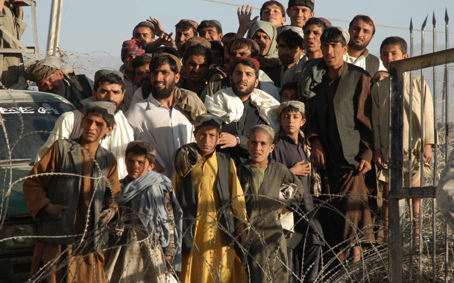 People wait to cross the Afghanistan-Pakistan border Monday while it was briefly closed during a visit by U.S. Ambassador to Afghanistan Ken Eikenberry. The ambassador came to the crossing to see what measures are in place.