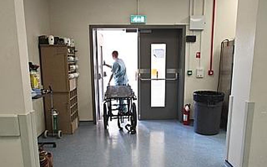 A trauma room staff member at Kandahar Airfield's Role 3 hospital wheels a gurney that has just been used to bring in a wounded U.S. soldier back outside where it will wait for the inevitable next patient. 