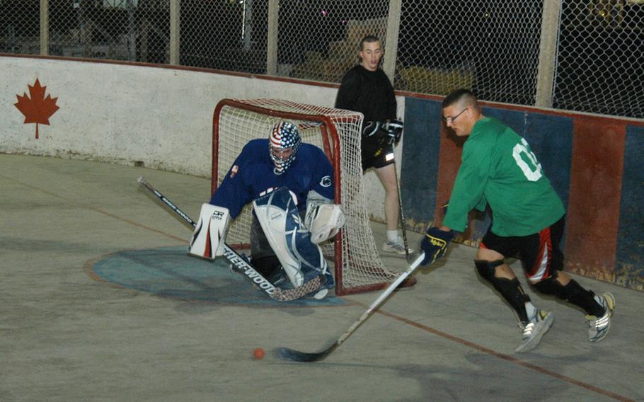 Army Capt. Ken Schoonover, the goalie, prepares to block a shot during a scrimmage of American players preparing for the upcoming ball hockey season at Kandahar Air Field in southern Afghanistan. Schoonover served as captain of the lone American team in the 24-team league last season, and wore a mask painted in an American flag design by his mother.