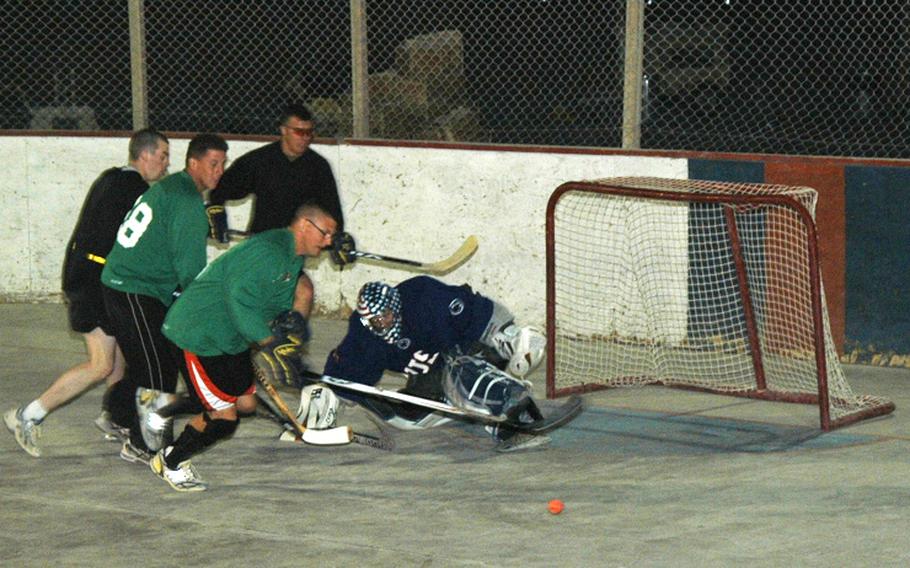 Capt. Ken Schoonover, the goalie and outgoing captain of the U.S. team in the ball hockey league at Kandahar Air Field, makes a kick save during a recent scrimmage of American players in southern Afghanistan.