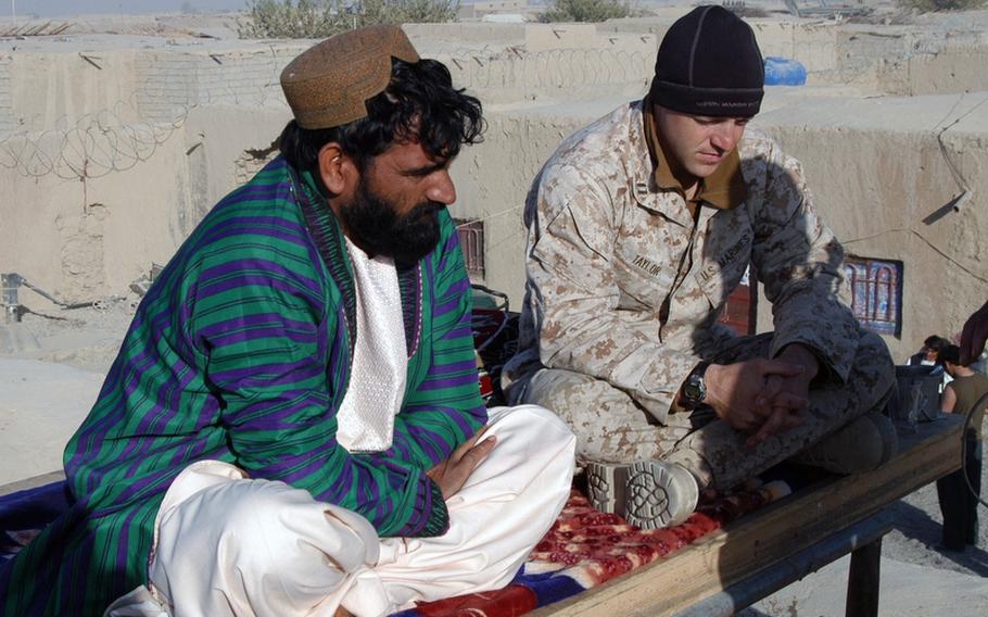 Afghan National Police Garmsir District Chief Omar Jan, left, confers with Capt. Matthew Taylor, the officer in charge of the police advisory team in the Garmsir District of Afghanistan for the 2nd Battalion 1st Marines, on a roof overlooking adjacent compounds where the ANP and Marines live. Jan says his men need more training and education from the Marines before they will be able to handle the defense of their district on their own.