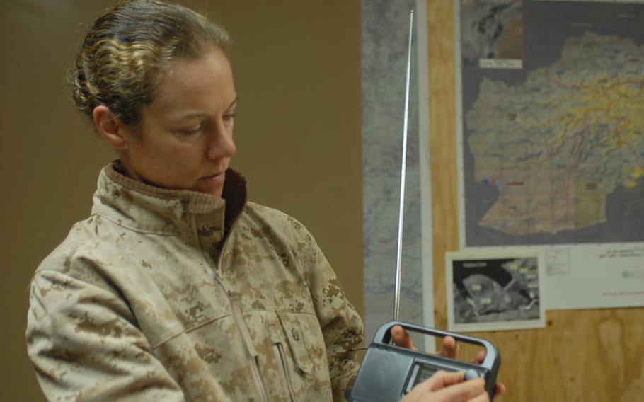 Maj. Nina D'Amato, education officer and gender adviser for Regional Command Southwest, holds a Chinese-made crank radio that ISAF troops have distributed to Afghans by the scores of thousands over the past four years. Now the command, along with RC-South, are going to air a daily radio program in Pashto to teach Afghan women to read.