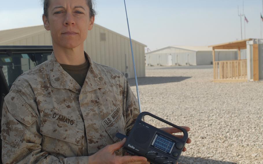 Maj. Nina D'Amato, education officer and gender adviser for Regional Command - Southwest, holds a Chinese-made crank radio that ISAF troops have distributed to Afghans by the tens of thousands over the past four years. Now the command, along with RC-South, are going to air a daily radio program in Pashto to teach Afghan women to read.