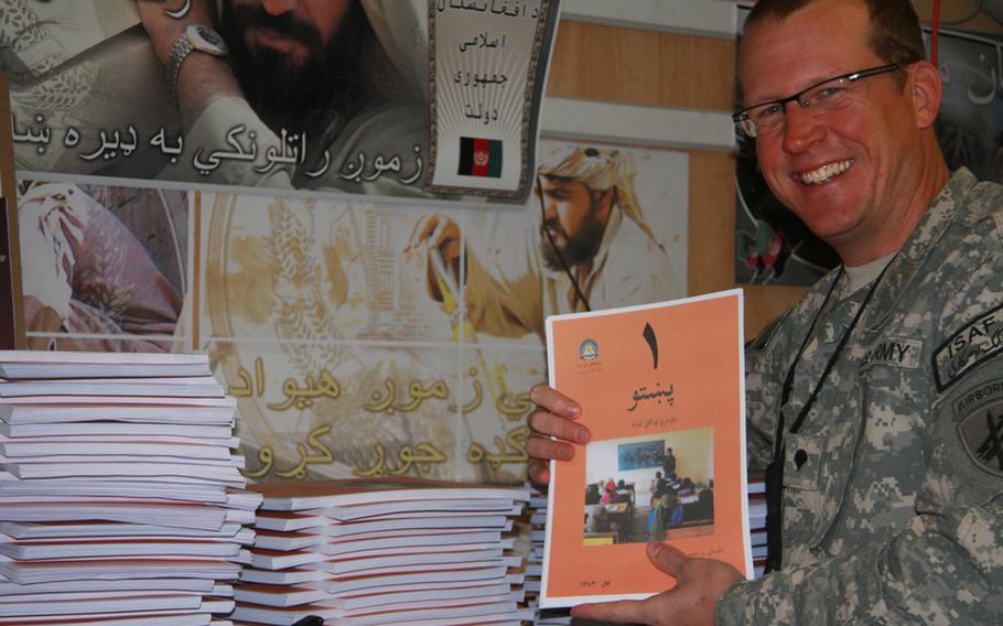 Army reservist Spc. Jim Daniels, an educator and curriculum specialist in civilian life, holds one of some 50,000 reading booklets for a radio literacy program he helped devise during his deployment with the 344th Military Information Support Operations Company (formerly known as psyops) at Kandahar Airfield. Aimed primarily at house-bound Afghan women, who have among the lowest literacy rates in the world, the effort is believed to be the first 'distance learning' program ever in Afghanistan.