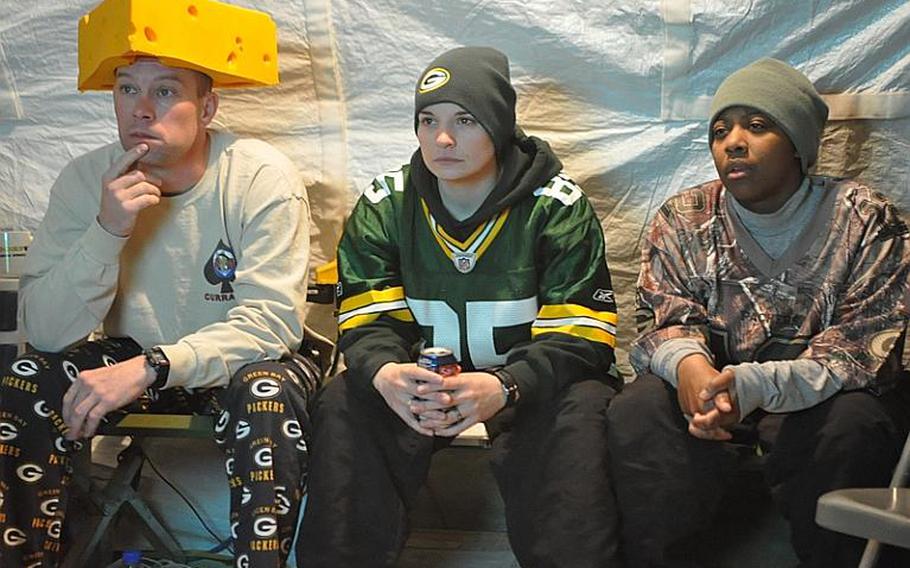 From left to right, 1st Sgt. Brandon Perry, 37; Sgt. Kali Tackitt, 23; and Spc. Natalie Smith, 24, watch the Packers and the Steelers go at it in Super Bowl XLV at icy Forward Operating Base Sharana in Paktika province in eastern Afghanistan.