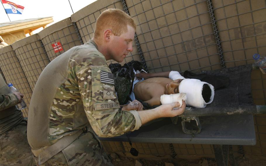 U.S. Army Pfc. Jacob Steffan treats an injured Afghan boy at Combat Outpost Nalgham, Afghanistan. The boy was injured in a firefight Sunday in the village of Sarkilla.