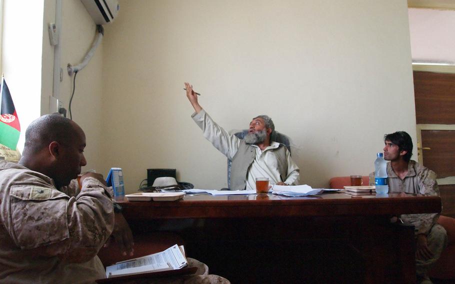 Marine Maj. Jason Johnson meets with Nawa District Governor Abdul Manuf in his office in the district center, adjacent to Patrol Base Jaker. Manuf asked Johnson to fix an air conditioner, like the one he's pointing to, in his living quarters.