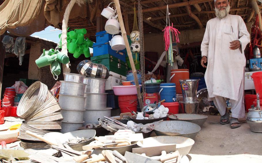 A shopkeeper greets Marines from Company G, 2nd Battalion, 3rd Marines as they patrol the main bazaar in Nawa district.