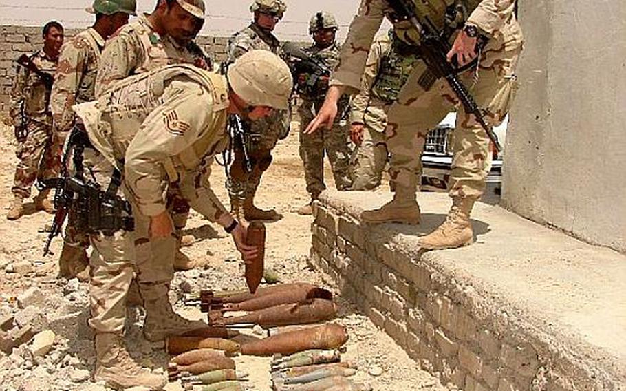 Kristoffer Solesbee, right, then a staff sergeant, describes identification features and safety concerns of various unexploded ordnance as Staff Sgt. Christopher Stoup shows the ordnance to Iraqi soldiers from the 5th Iraqi Army Bomb Disposal Company in Iraq in a 2006 photo.   Courtesy of U.S. Air Force