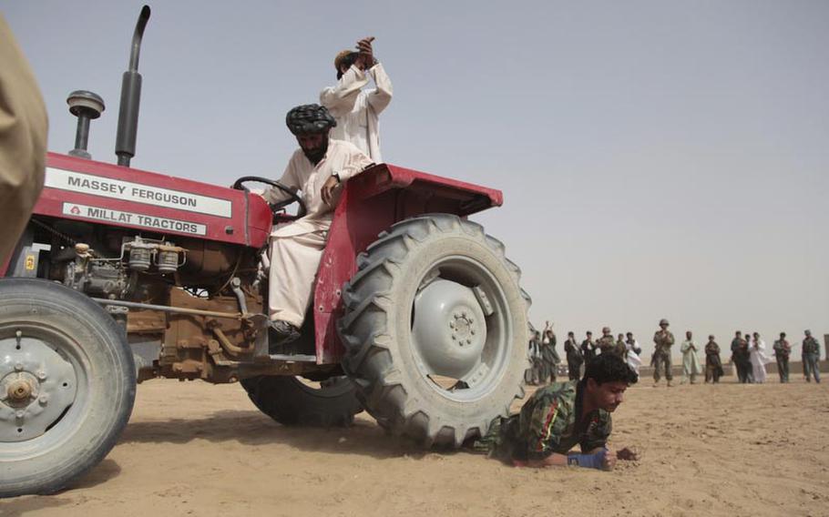Noor Agah, 23, a karate instructor in Safar, a town near the southern end of Garmsir district in Afghanistan&#39;s Helmand province, maintains his cool as a tractor runs over his legs.