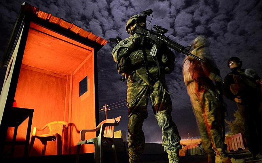 Sgt. Steven Spurrell with 2nd Battalion, 5th Cavalry Regiment, 1st Brigade, 1st Cavalry Division, stands at the ready while visiting an Iraqi police station in Tunis, Iraq, during a night patrol conducted from Contingency Operating Station Kalsu near the city of Hilla, Iraq.