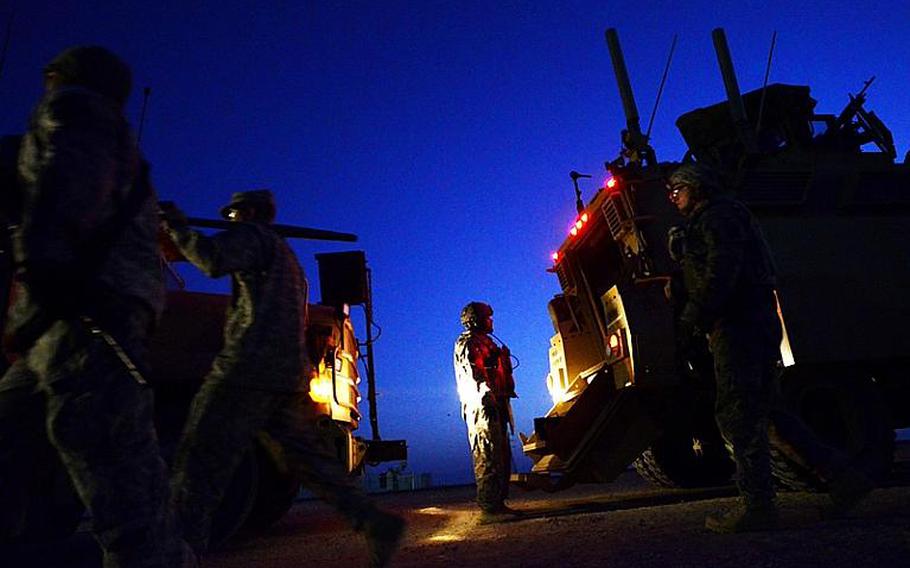 U.S. soldiers in the last convoy to leave Iraq pause to prepare to process through Kuwait customs after safely crossing the Kuwait border at the Khabari crossing.