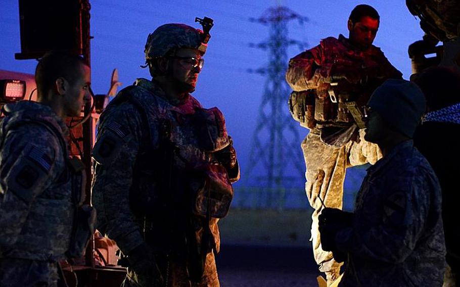 U.S. soldiers in the last convoy to leave Iraq receive a briefing before processing through Kuwait customs after safely crossing the Kuwait border at the Khabari crossing.