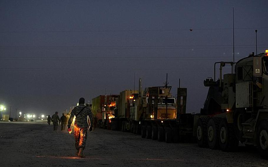 U.S. soldiers in the last convoy to leave Iraq pause to prepare to process through Kuwait customs after safely crossing the Kuwait border at the Khabari crossing.